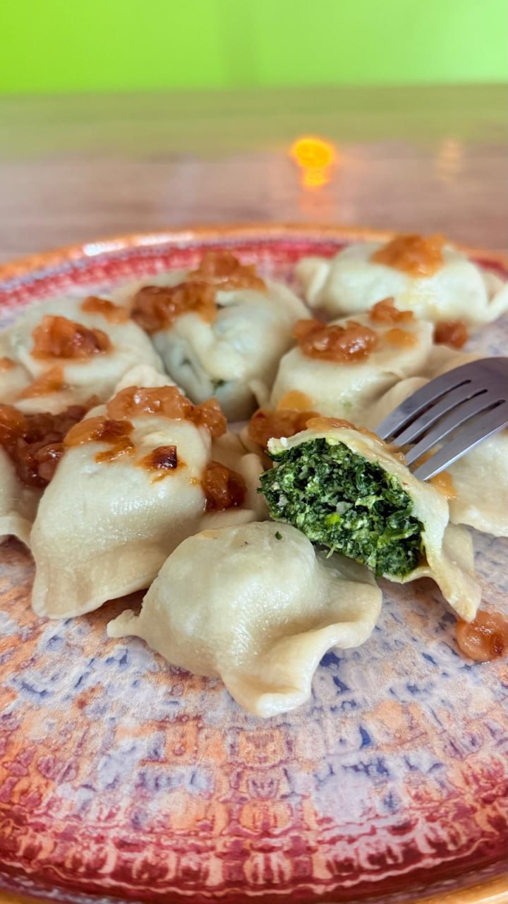 Pierogi gevuld met spinazie op een Pools folkloristisch bord